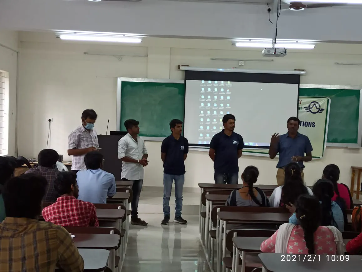 A group of men stand at the front of a classroom addressing seated students, with a projector screen and green boards in the background. The discussion centers on integrated supply chain management principles, as part of a Jane seminar. The photo is dated 2021/2/1 10:09.
