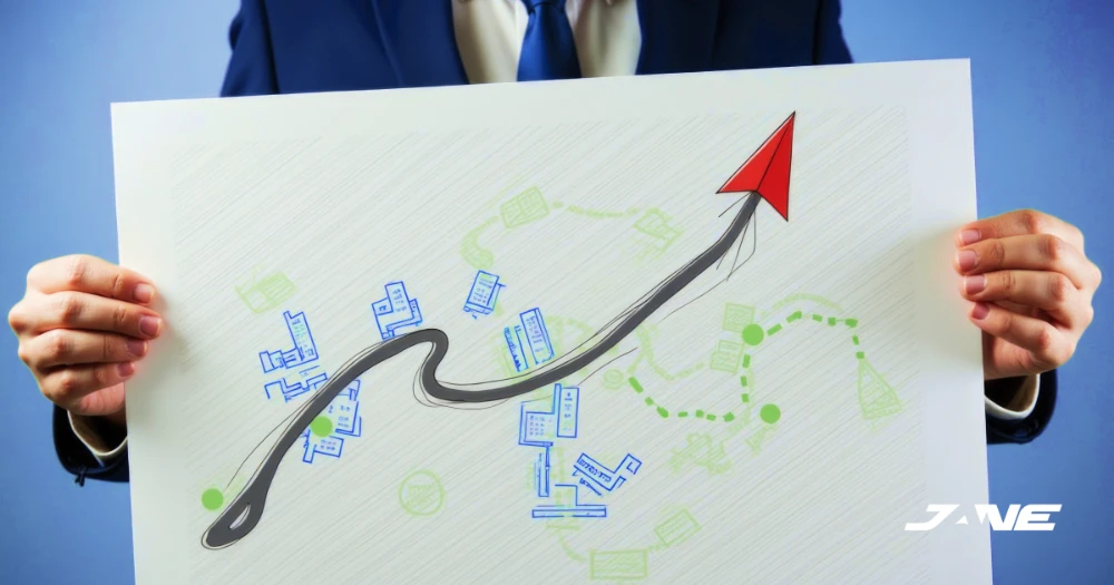 A person holding a drawing sheet with a growing up-wards arrow graph on top of a plan.